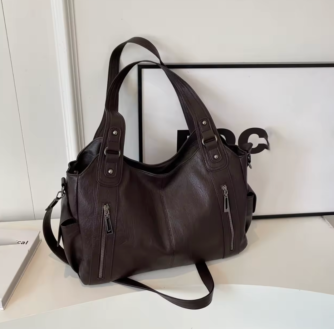 Grand sac cabas noir pour femme avec plusieurs compartiments, pouvant accueillir un ordinateur portable, une tablette et les essentiels du quotidien.